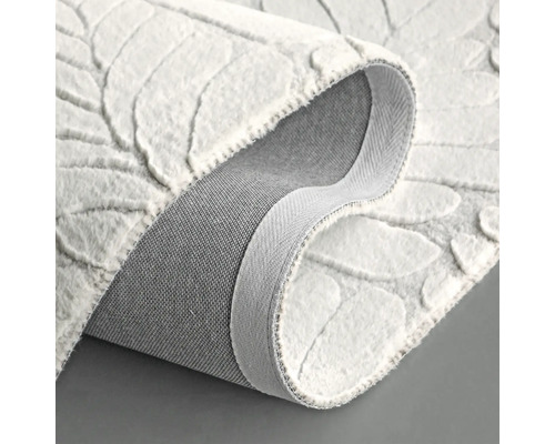 Bílý koberec s listovým vzorem, zobrazený srolovaný