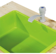 Zelená hrací umyvadlo s vodovodní baterií na dřevěném stole