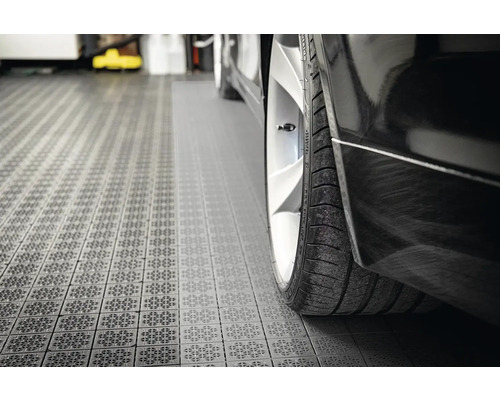 Detailní pohled na černé auto na garážových dlaždicích