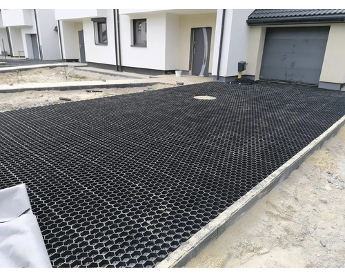 Příjezdová cesta s zatravňovacími dlaždicemi před obytnými domy