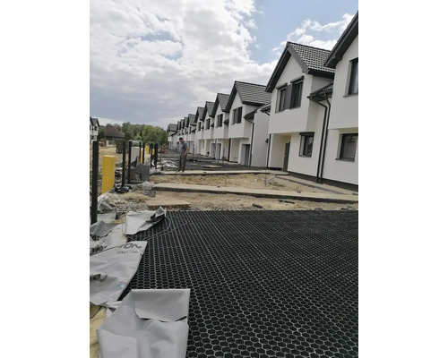 Řadová zástavba ve výstavbě s půdními rošty před domy