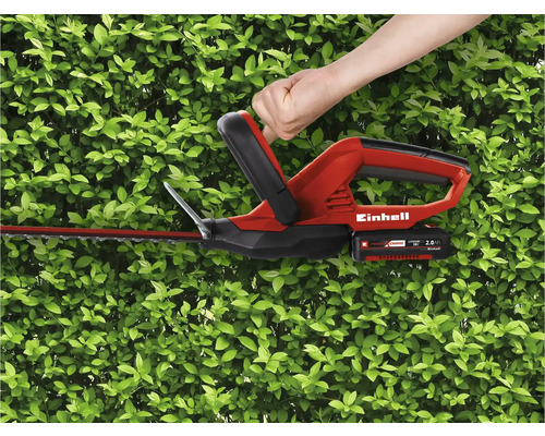Ovládání akumulátorových nůžek na živý plot Einhell před zeleným živým plotem