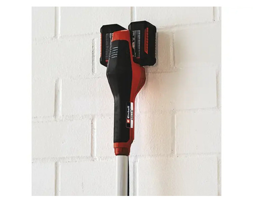 Akumulátorový vyžínač se dvěma bateriemi na zdi