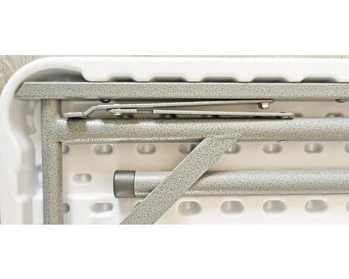 Detail skládacího stolu s kovovým rámem a mechanismem