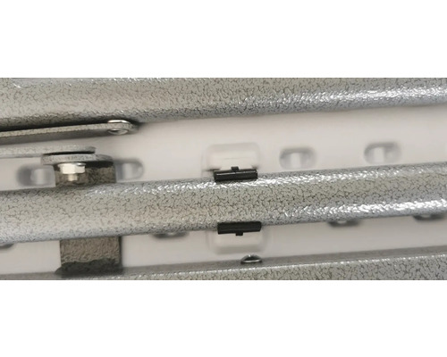 Detailní pohled na kovový regál se šrouby a plastovými klipy