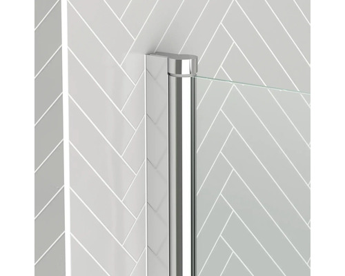 Detail sprchového koutu s chromovaným profilem a skleněnou stěnou před stěnou se vzorem rybí kosti