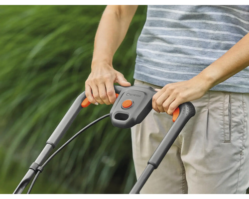 Osoba obsluhuje sekačku na trávu na zahradě.