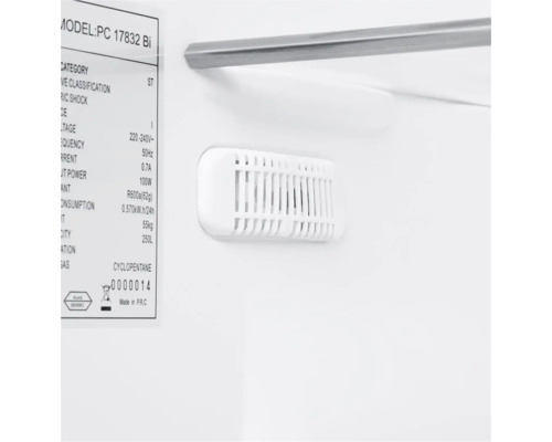 Vnitřek chladničky s chladicími žebry, štítkem a policí