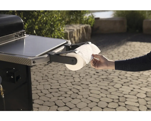 Gril s držákem na papírové utěrky a ruka odvíjející papír