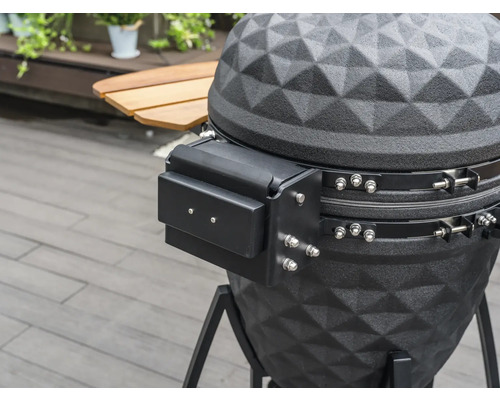 Detailní záběr černého grilu na dřevěné uhlí s úložným prostorem