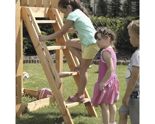 Děti si hrají na hrací věži s žebříkem na zahradě.
