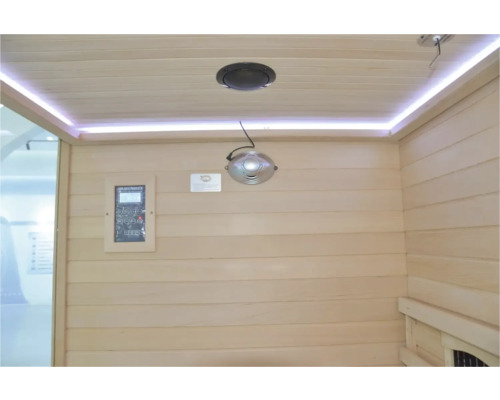 Interiér sauny s dřevěným obložením, reproduktorem, světelnou lištou a ovládacím panelem