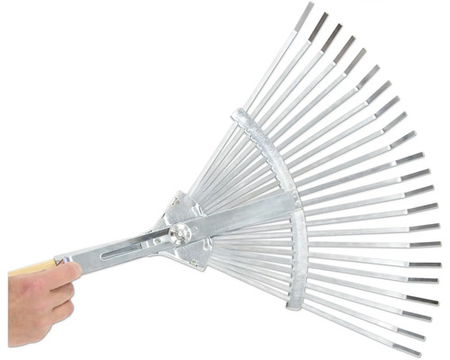 Kovové hrábě s nastavitelnými zuby drží ruka.