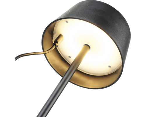Detailní záběr stolní lampy s kulatou základnou a stínidlem.