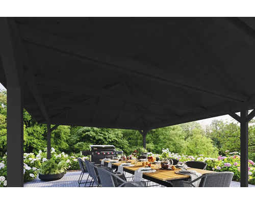 Zastřešená terasa s jídelním stolem a grilem v pozadí