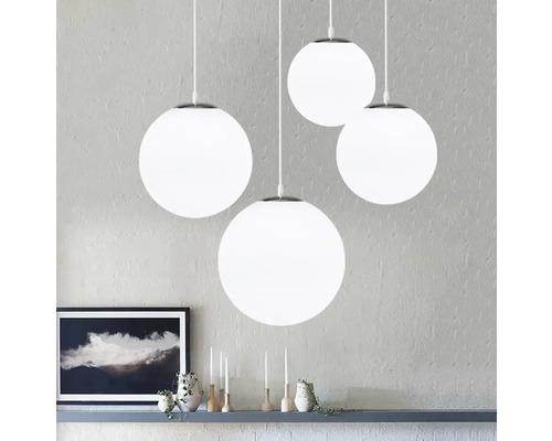 Čtyři kulatá závěsná svítidla s bílými kulovými stínidly visí v místnosti.