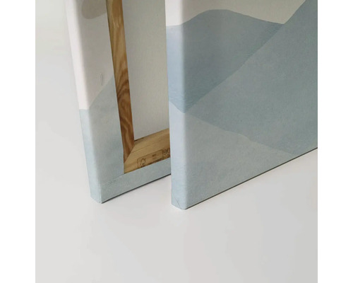 Detailní pohled na dva obrazy na plátně s abstraktními motivy hor a dřevěným rámem