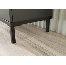 Detailní záběr koupelnového nábytku s kovovými nohami na dřevěné podlaze.