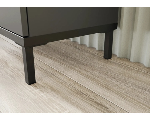 Detailní záběr koupelnového nábytku s kovovými nohami na dřevěné podlaze.