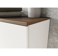 Detailní záběr koupelnové skříňky s dřevěnou deskou a bílým čelem