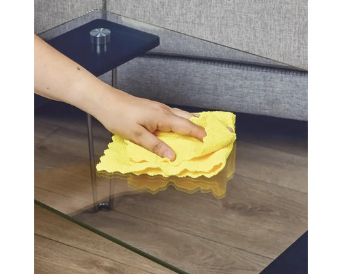 Čištění skleněného stolu žlutým hadříkem z mikrovlákna