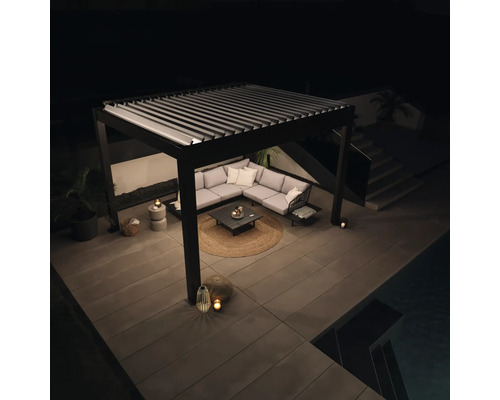 Terasa s lamelovou střechou, rohovou sedačkou a zahradním stolkem v noci