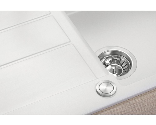 Detailní pohled na bílý kuchyňský dřez s odtokem a excentrickým ovládáním