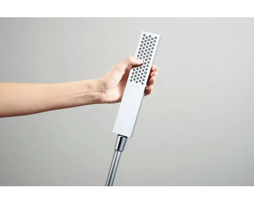 Ruční sprcha s hadicí držená v ruce