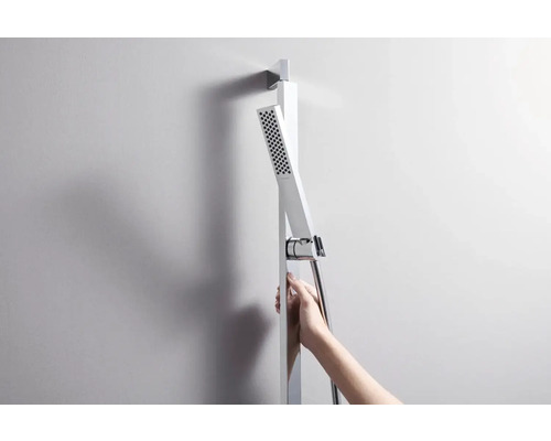 Sprchový sloup s ruční sprchou a sprchovou hadicí na zdi