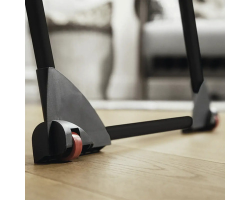 Detail rolovacího stojanu s kolečky na dřevěné podlaze