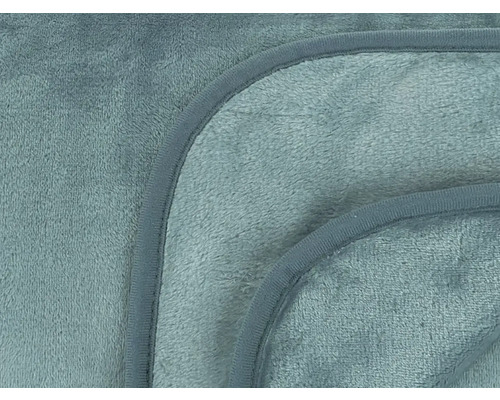 Detailní záběr na hebkou, olemovanou deku