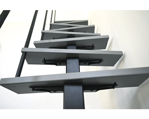 Detailní pohled na prostorově úsporné schodiště s kovovými stupni a zábradlím