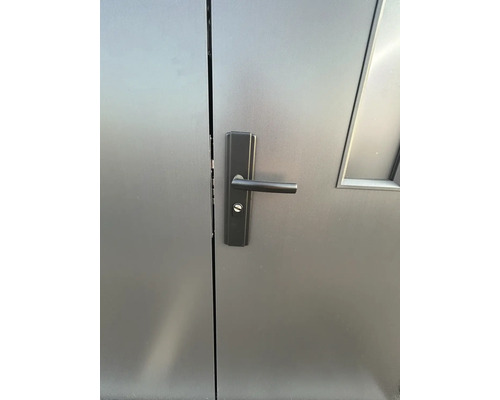 Detail šedých dveří s klikou