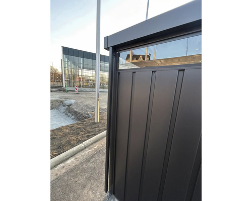 Detailní pohled na černý zahradní domek s oknem