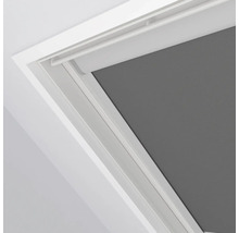 Šedá roleta v střešním okně s bílým rámem