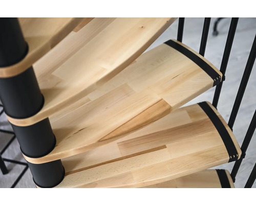 Detailní pohled na točité schodiště s dřevěnými schody a černým kovovým zábradlím.