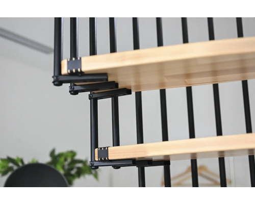 Detailní pohled na točité schodiště s dřevěnými stupni a černým kovovým zábradlím