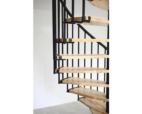 Detailní pohled na točité schodiště s dřevěnými stupni a kovovým zábradlím