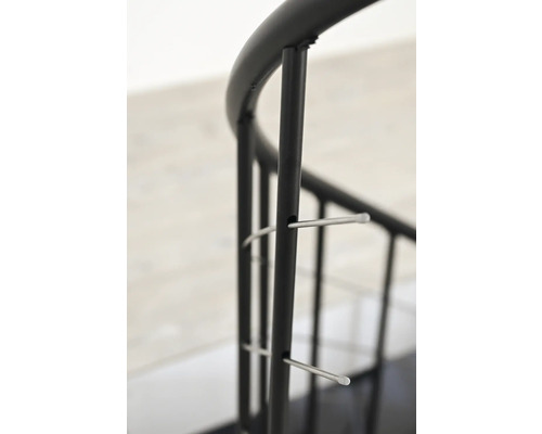 Detailní pohled na černé kovové zábradlí pro točité schodiště.