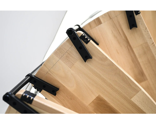 Detailní pohled na schodiště s dřevěnými stupni a černými kovovými prvky pro úsporu místa