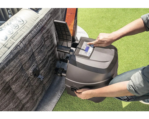 Osoba obsluhuje ovládací panel vířivky vedle nafukovací vířivky.