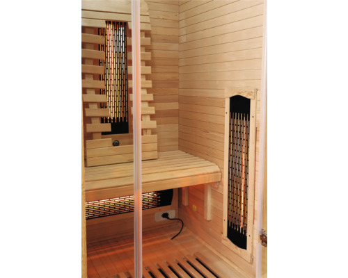 Vnitřní pohled na dřevěnou saunu s lavicemi a infračervenými zářiči