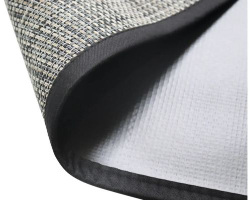 Detailní záběr prostírání s tkaným povrchem a černým okrajem