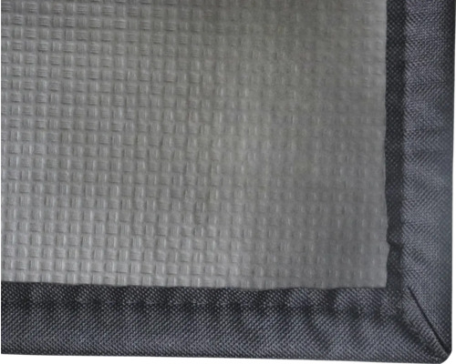 Detail textilie se strukturovaným povrchem a lemovaným okrajem