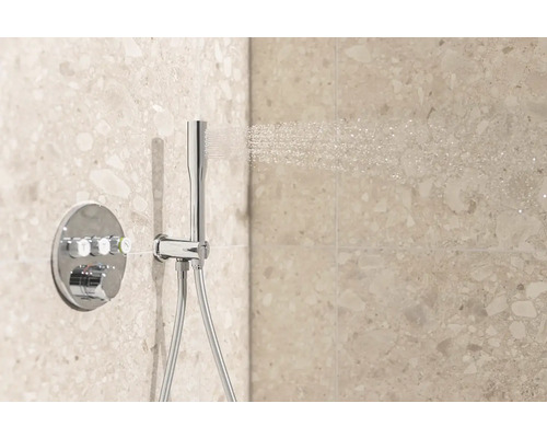 Nástěnný sprchový termostat s ruční sprchou a sprchovou hadicí před stěnou