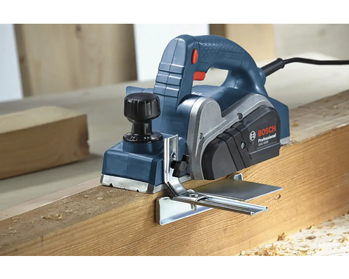 Elektrický hoblík při hoblování dřevěné desky.