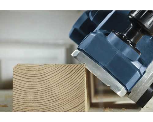 Elektrický hoblík v provozu na dřevěném obrobku.