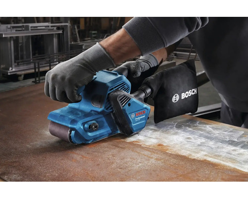 Operátor v rukavicích používá pásovou brusku na kovovém povrchu, Logo Bosch