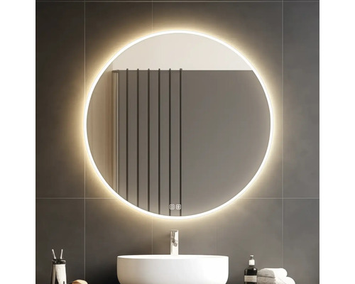 Osvětlené kulaté zrcadlo nad umyvadlem v koupelně