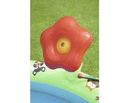 Nafukovací brouzdaliště s červenou postřikovací hlavicí na zahradě.